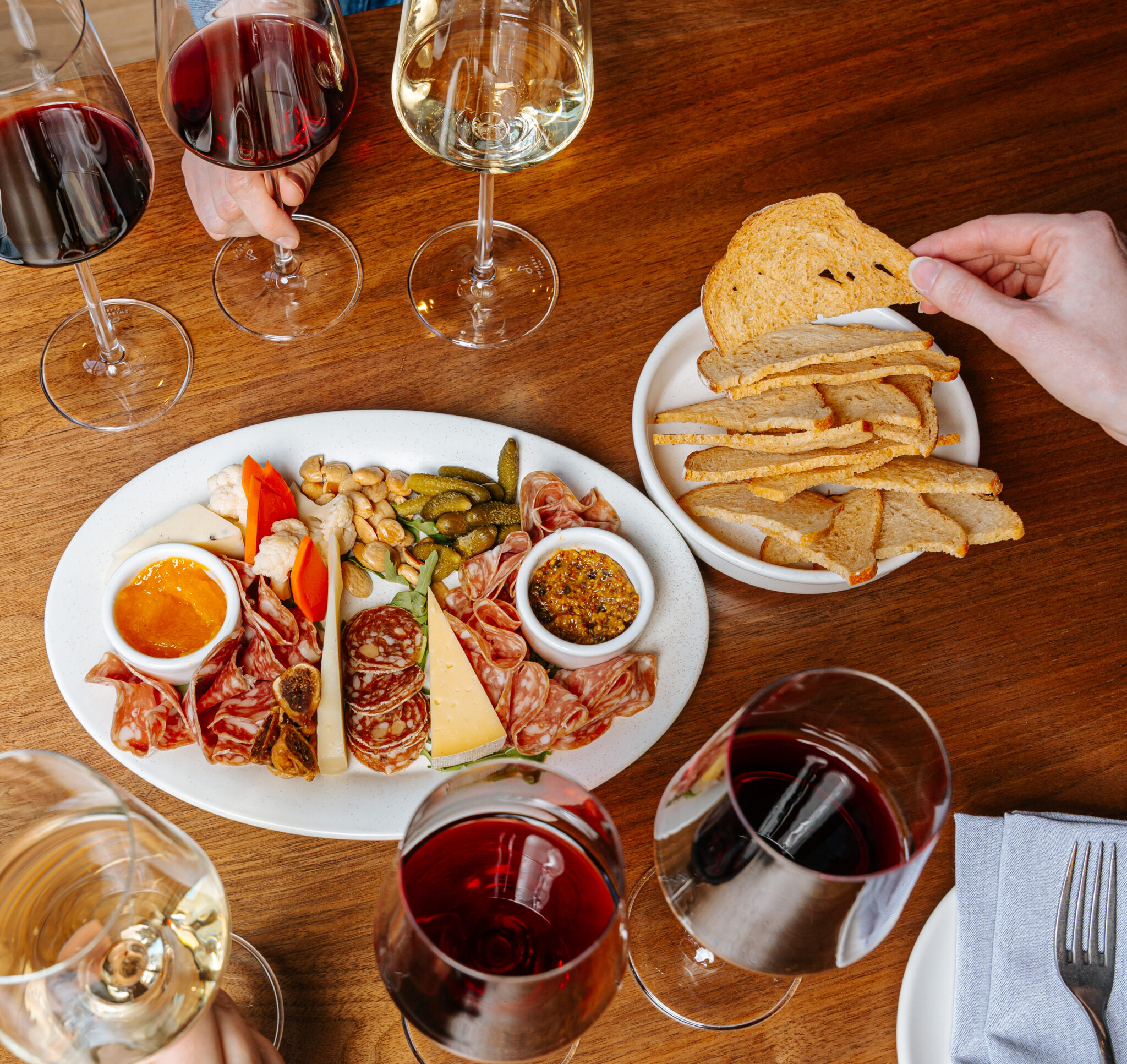 Glasses of wine next to cheese and charcuterie plate