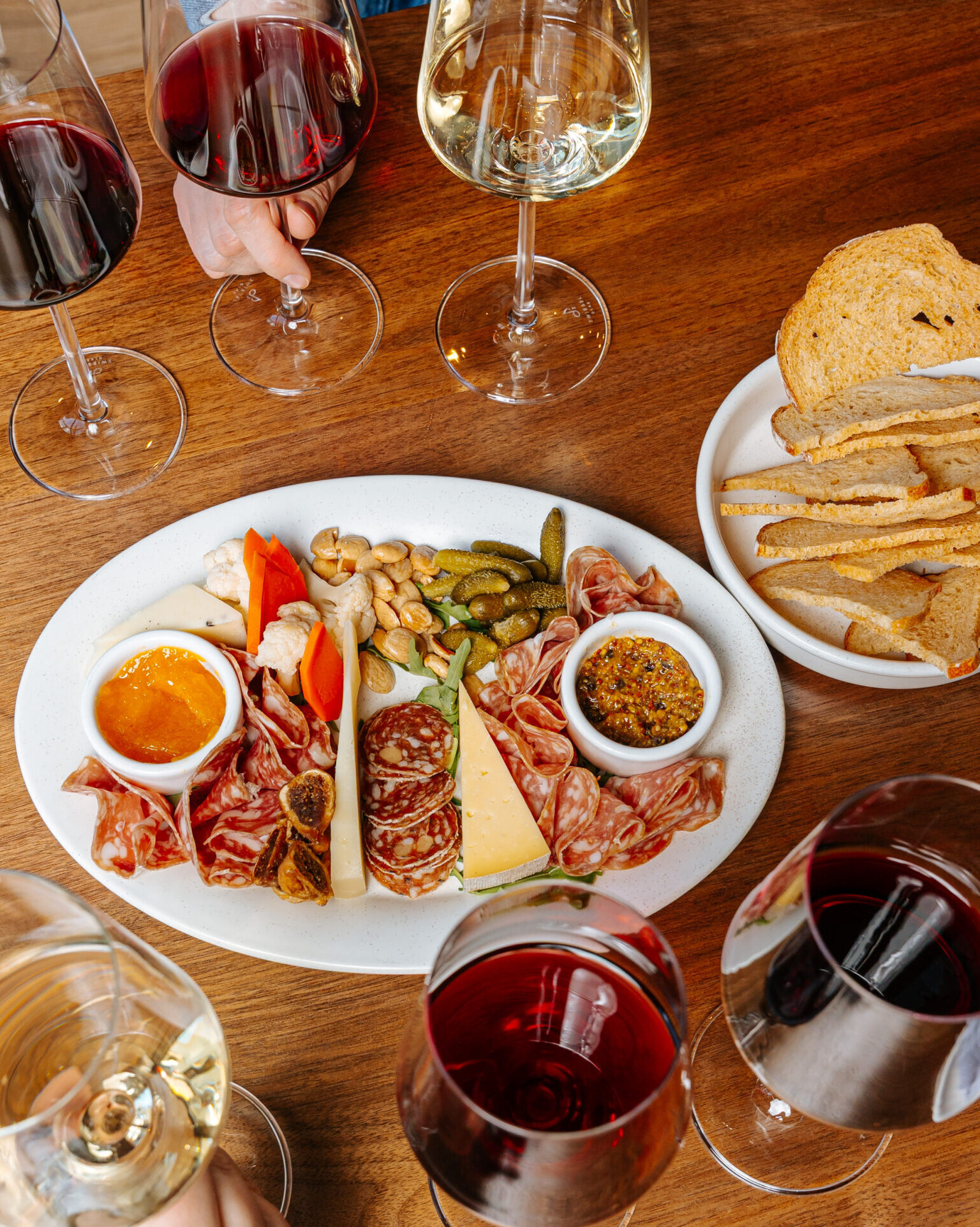 Glasses of wine next to cheese and charcuterie plate